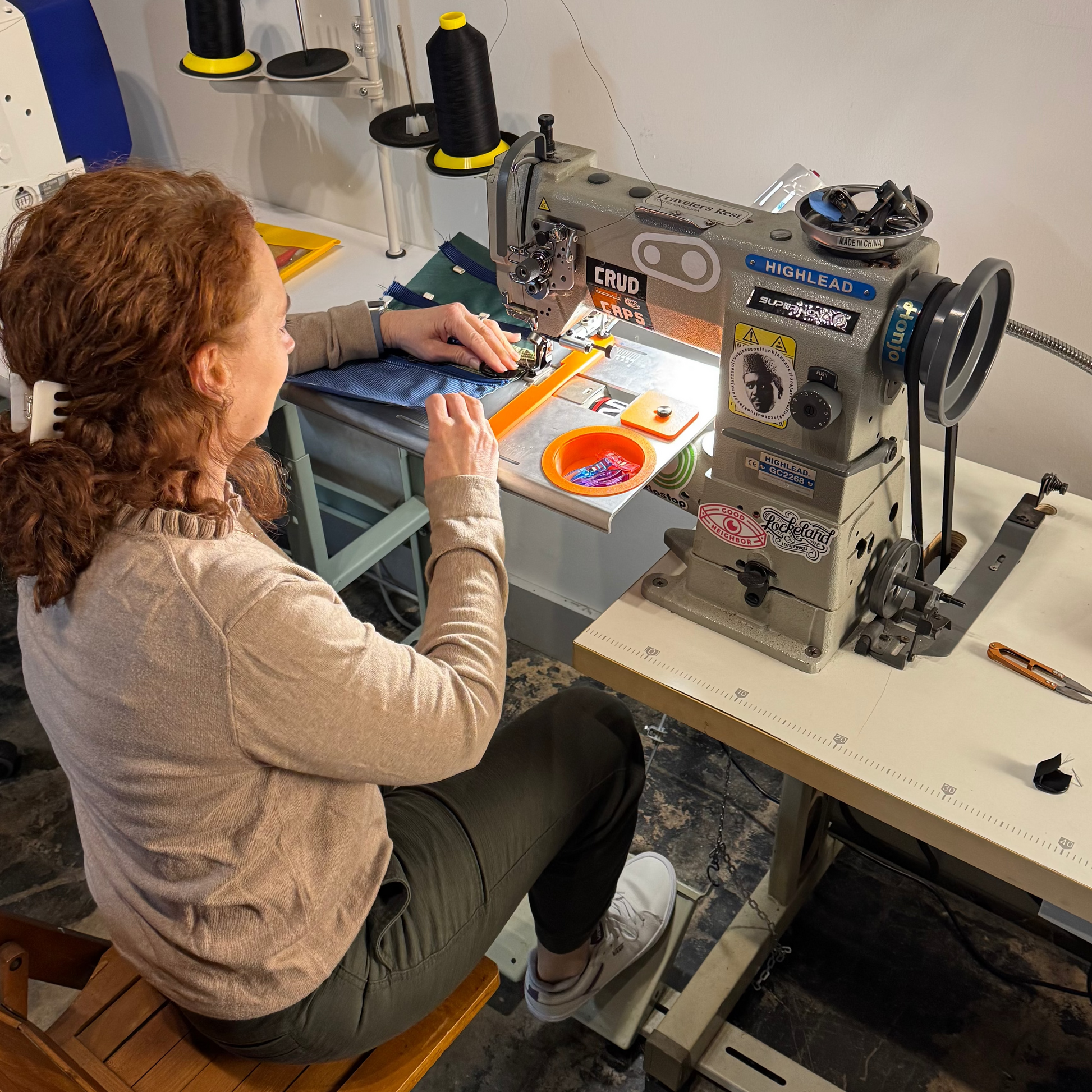 Person working on a sewing machine in a workshop setting